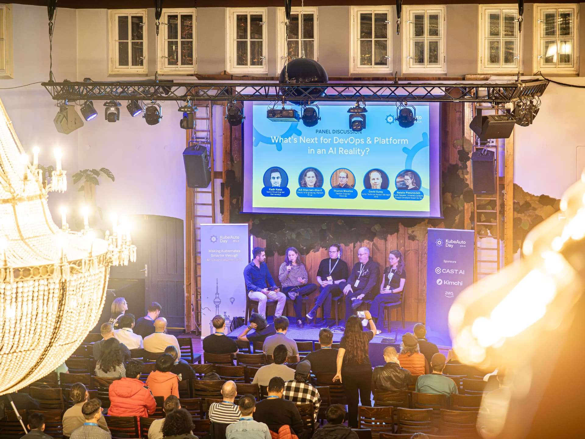 Panel discussion under the chandeliers at KubeAuto Day Berlin