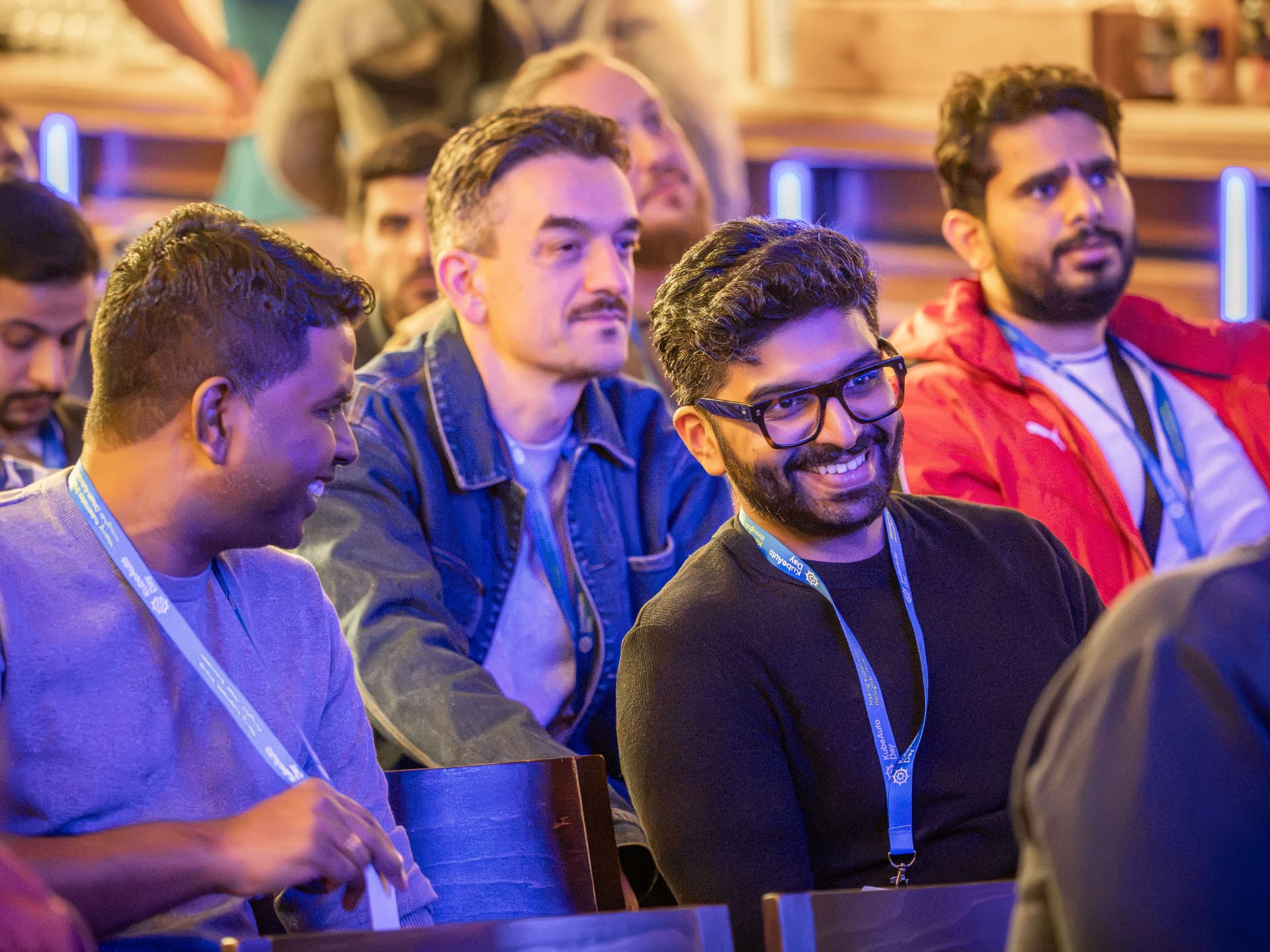 Attendees smiling and chatting in the audience at KubeAuto Day Berlin